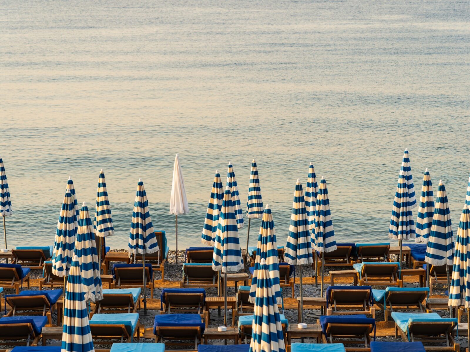 Rows,Of,Closed,Blue,And,White,Striped,Beach,Umbrellas,And